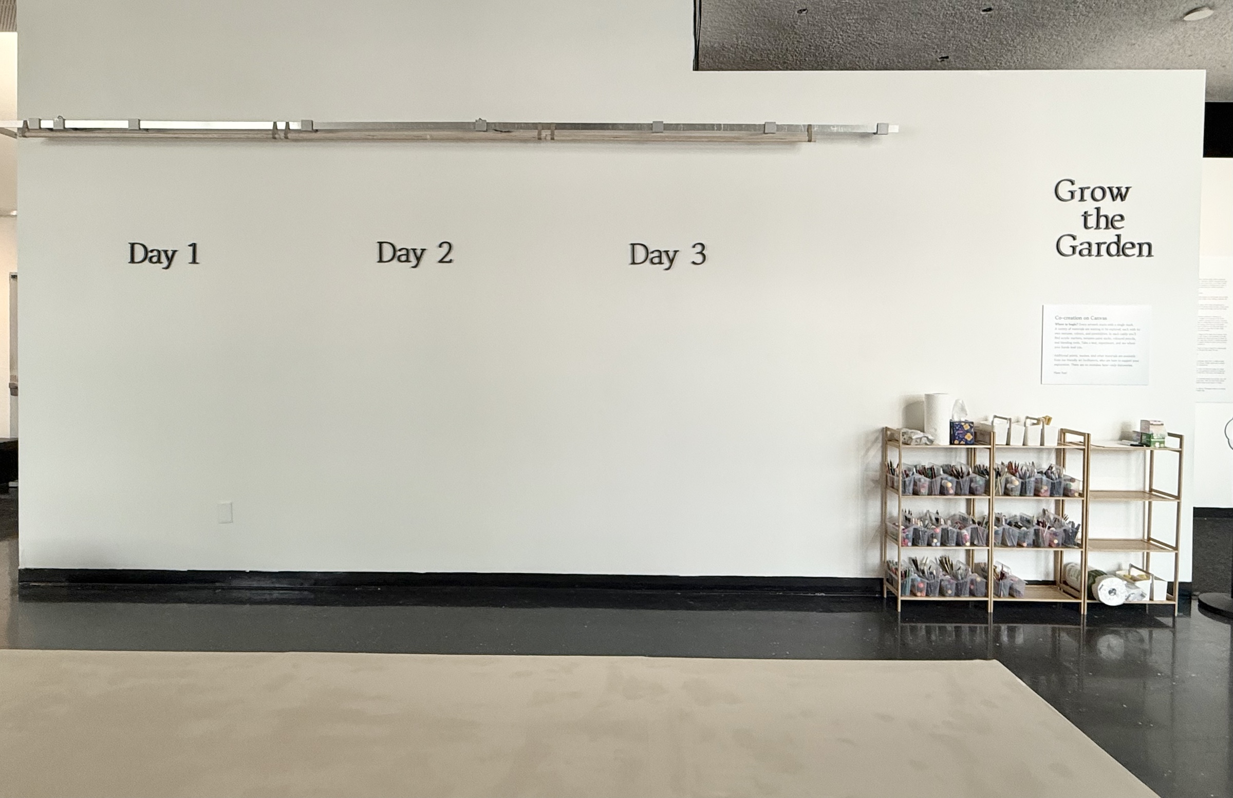 The blank three-day collaborative canvas wall and prepared art-material caddies before Opening Day.
