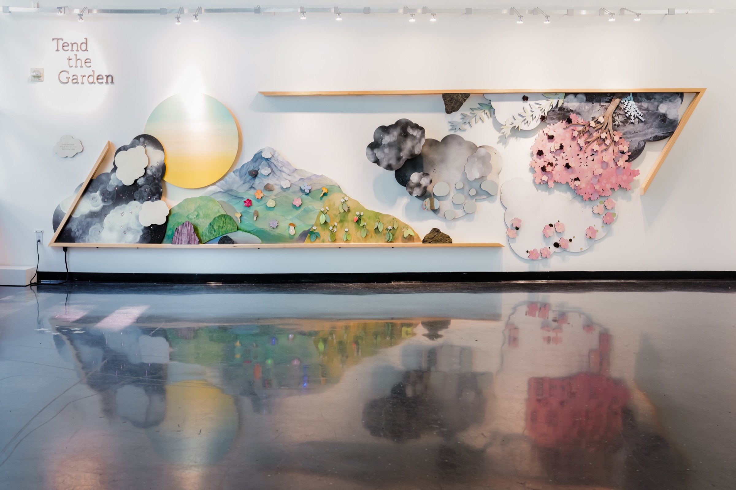 Wide, straight-on view of the hand-painted Tend the Garden installation reflected in the gallery floor at Bellevue Arts Museum.