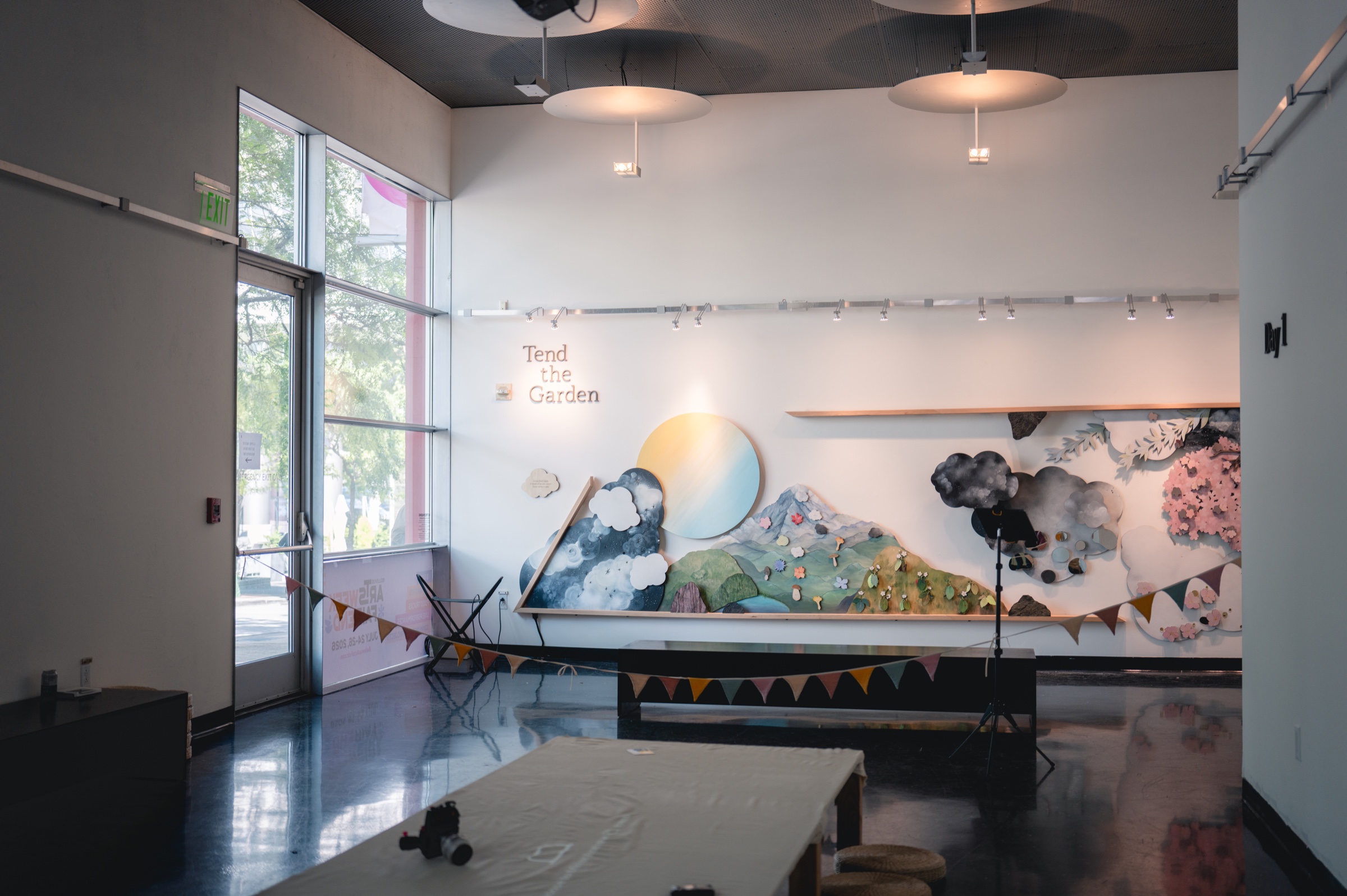 A wide gallery view of Tend the Garden and the collaborative making tables prepared for visitors at Bellevue Arts Museum.